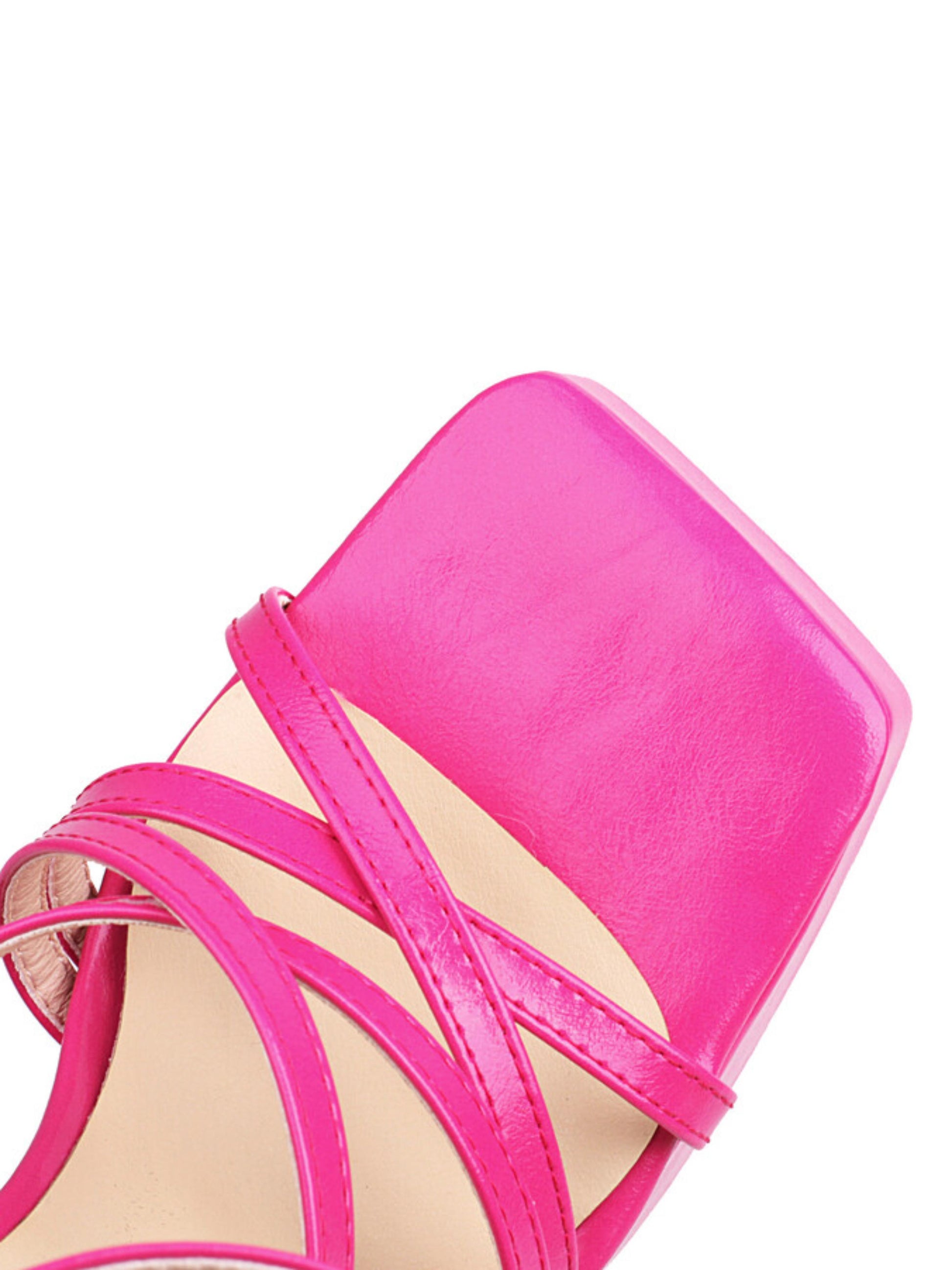 Close-up of a bright pink high-heeled sandal with strappy design
