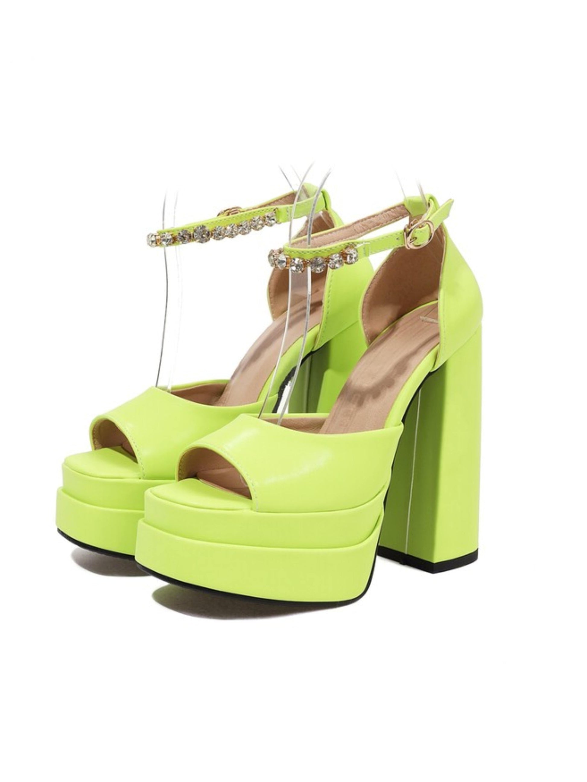 Pair of neon green high-heeled platform shoes with rhinestone straps